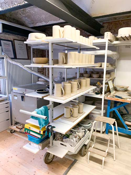 Geformte Keramik und Porzellan in einem Regal, in der Töpferwerkstatt von Heigert & Möbs.
