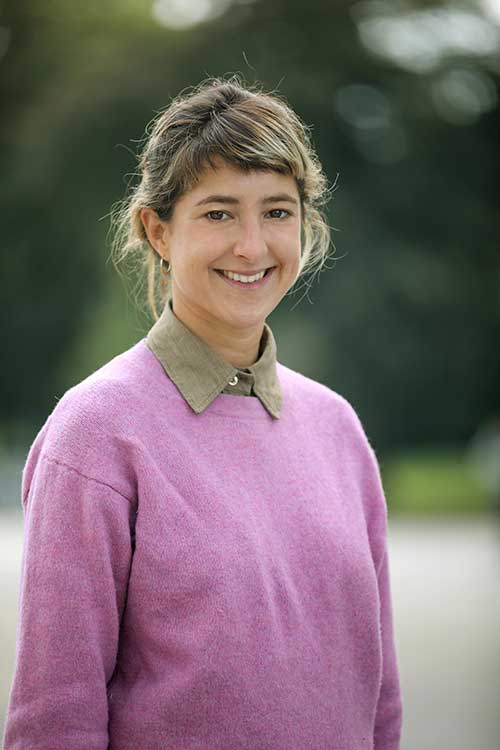 Portrait der Autorin Julia Salzmann in pinkem Pulli vor verschwommenem Hintergrund