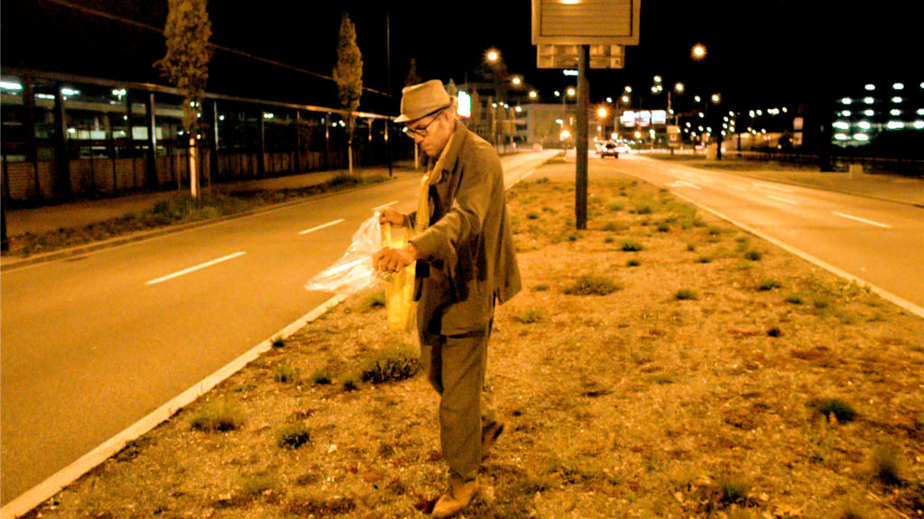 Maurice Maggi sät nachts im Schein der Straßenlampen Samen auf einem Seitenstreifen in Zürich aus.