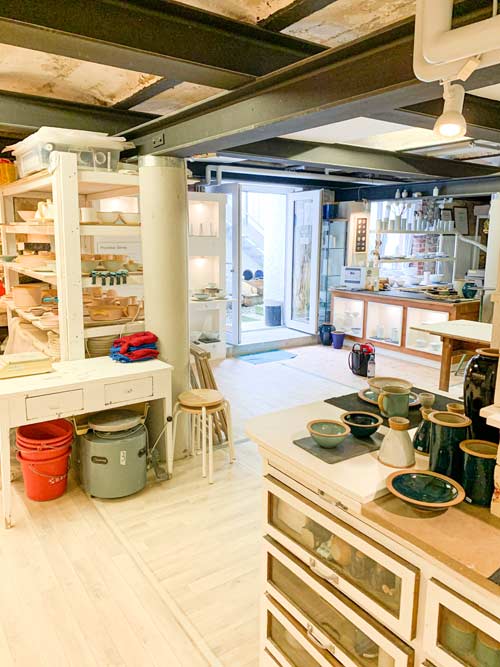 Werkstatt von Heigert & Möbs, mit zahlreichen Regalen, gefüllt mit Keramik und Porzellan.