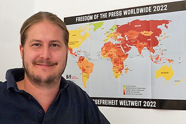 Fabian Ekstedt neben Weltkarte der Pressefreiheit 2022